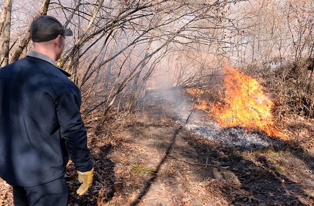 Fort Leavenworth Fire and Emergency Services Firefighter Branon Ward helps monitor a prescribed burn in progress Nov. 17 along a multi-use trail near Sheridan Drive. "Pocket prairies" along the trail were identified several years ago in a...