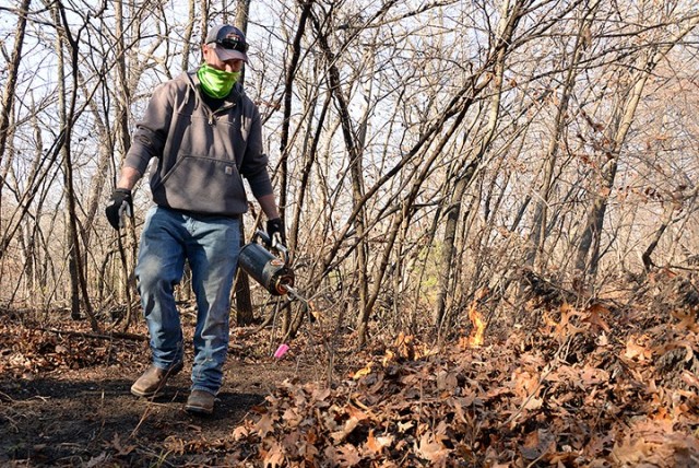 Ryon Mingo, heavy equipment operator with the Directorate of Public Works, uses a drip torch to light the perimeter of a prescribed burn Nov. 17 on a trail off Sheridan Drive. DPW personnel attended a prescribed burn workshop with the Fort...