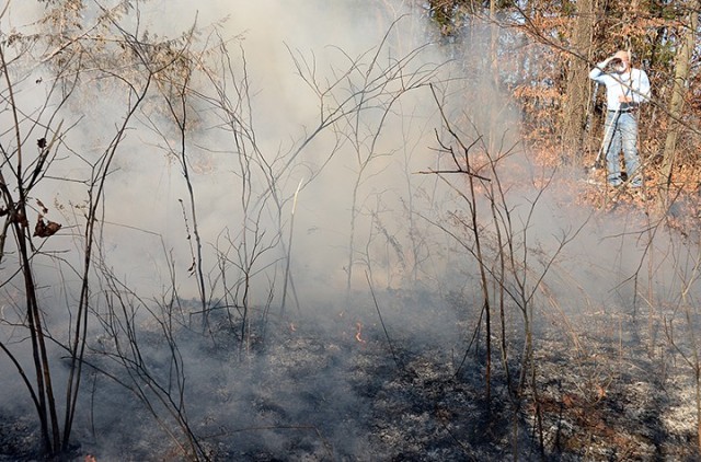 Fort Leavenworth Natural Resources Specialist Neil Bass helps monitor a prescribed burn in progress Nov. 17 along a multi-use trail near Sheridan Drive. "Pocket prairies" along the trail were identified several years ago in a biological survey as...