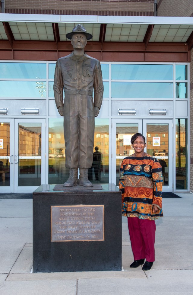 Regina Norris, a supply technician with the Drill Sergeant Academy, poses by the drill sergeant statue Nov. 9.