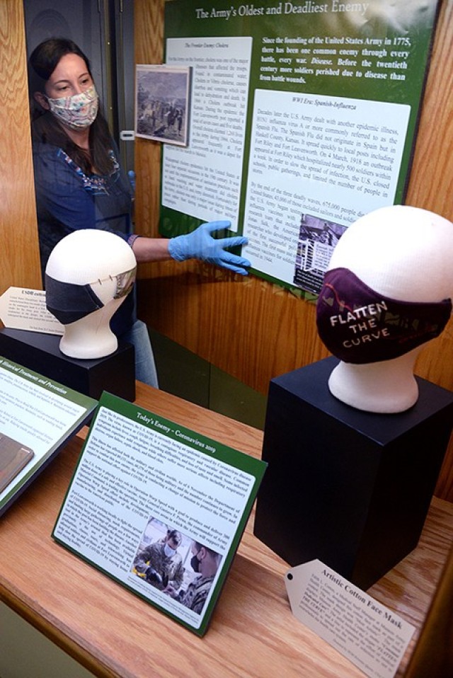 Museum Specialist Megan Hunter positions display materials while installing a new exhibit on disease — "The Army's Oldest and Deadliest Enemy" — Nov. 16 at the Frontier Army Museum. The exhibit features masks and information from the ongoing...