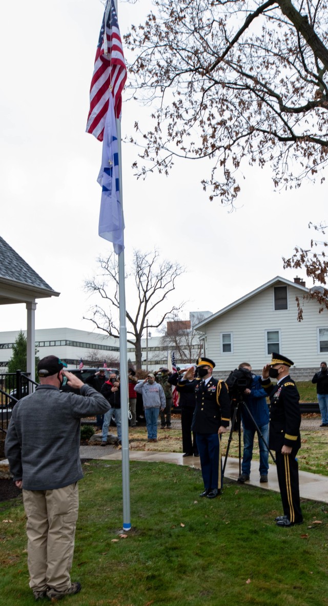 A U.S. flag that was flown over Rock Island Arsenal, Ill., in honor of Korean War veteran J.P. Whitaker is raised during a ceremony welcoming Whitaker back to his refurbished home.