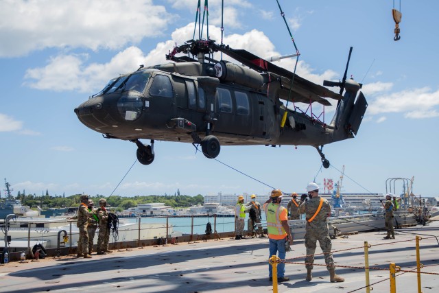 Soldiers assigned to 2nd Infantry Brigade Combat Team, and the 25th Combat Aviation Brigade, 25th Infantry Division work together to load a UH-60 Blackhawk Helicopter about a cargo ship in preparation for movement to the Joint Readiness Training Center at Fort Polk, Lousiana on Pearl Harbor, Hawaii on Aug. 29, 2020. (U.S. Army photo by Staff Sgt. Alan Brutus)