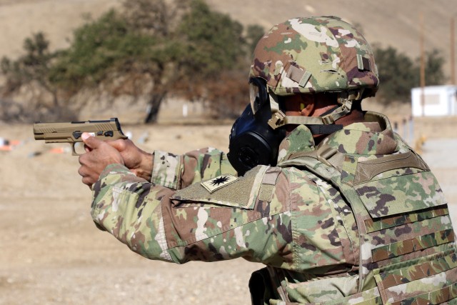 Capt. Jason Boatwright, commander of the 40th Combat Aviation Brigade, Headquarters Headquarters Company, 40th Combat Aviation Brigade, fires his weapon while wearing his protective mask on the pistol range at Camp Roberts, Nov. 13, 2020. (U.S. Army National Guard photo by Sgt. 1st Class Ryan Sheldon)