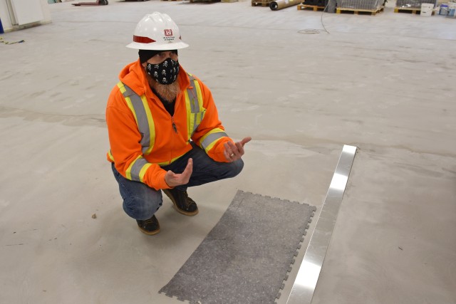 WIESBADEN, Germany – Chad Adamson, construction control representative with the U.S. Army Corps of Engineers Europe District, explains about the material the new floor of the post office building will consist of Nov. 17, 2020.