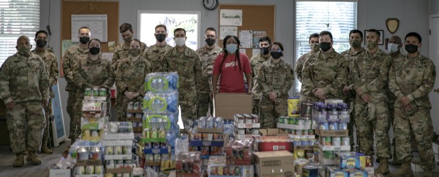 Soldiers with 504th Expeditionary Military Intelligence Brigade pose for a group photo with members of the Nolanville First United Methodist Church, Nov. 20, 2020, Nolanville, Texas. The food will be transferred to the food pantry for distribution. (U.S. Army photo by Spc. Tyler Tanaka)