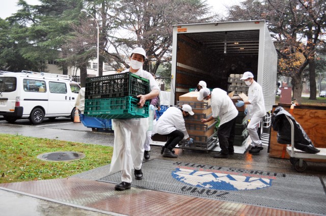 Camp Zama Dining Facility staff carry food into the Yano Fitness Center at Camp Zama, Japan, Nov. 25, for the traditional Thanksgiving luncheon.