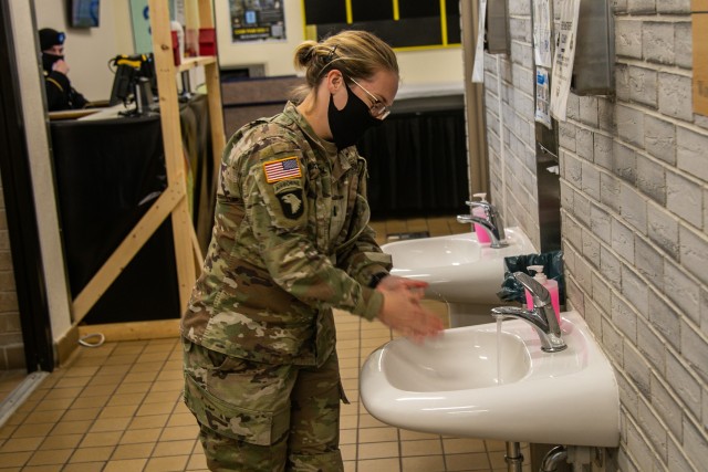 U.S. Army 1st Lt. Megan Mackinnon, assistant operations officer, Headquarters and Headquarters Company, 326 Brigade Support Battalion, washes her hands prior to entering Snipes Dining Facility to enjoy the Thanksgiving meal and festivities Nov. 24 on Fort Campbell, Ky. Bastogne brigade upheld its annual traditional Thanksgiving meal for Soldiers, Friends, and Families within the unit for fellowship and esprit de corps.