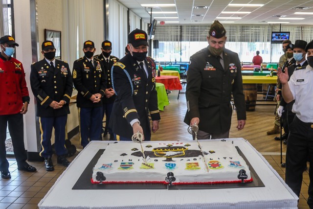 U.S. Army Col. Robert Born, brigade commander, 1st Brigade Combat Team "Bastogne", 101st Airborne Division (Air Assault), left, cuts the brigade Thanksgiving celebration cake with Maj. Gen. Brian Winski, commanding general, 101st Airborne Division (Air Assault), right, within Snipes Dining Facility Nov. 24 on Fort Campbell, Ky. Bastogne brigade upheld its annual traditional Thanksgiving meal for Soldiers, Friends, and Families within the unit for fellowship and esprit de corps.