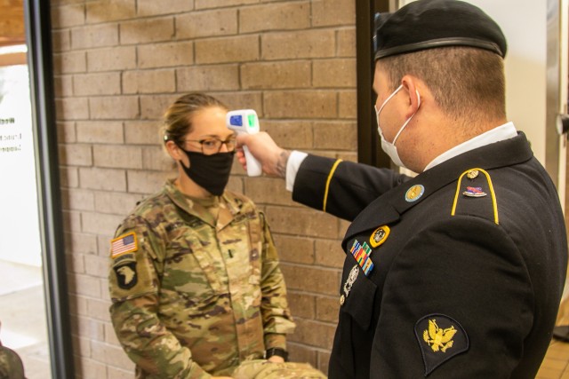 U.S. Army Spc. Luiz Seixas, infantryman, Company A, 2nd Battalion, 327th Infantry Regiment "No Slack", 1st Brigade Combat Team "Bastogne", 101st Airborne Division (Air Assault), right, checks the temperature of 1st Lt. Megan Mackinnon, assistant operations officer, Headquarters and Headquarters Company, 326 Brigade Support Battalion, left, at the entrance of Snipes Dining Facility Nov. 24 on Fort Campbell, Ky. Bastogne brigade upheld its annual traditional Thanksgiving meal for Soldiers, Friends, and Families within the unit for fellowship and esprit de corps.