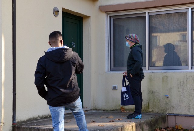 Sgt. Joseph Nuttall, BOSS advisor (right) and 2nd Lt. Luis Zamora deliver one of the Thanksgiving to-go meals on Villaggio, Nov. 26, 2020. The BOSS Vicenza program volunteers delivered 20 meals for Soldiers and family members in quarantine.