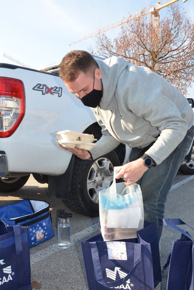 BOSS volunteer Pfc. Hunter Bowers adds some food items to the individual bags prepared for Thanksgiving to deliver on Villaggio. The BOSS Vicenza program volunteers delivered 20 meals for Soldiers and Families in quarantine Nov. 26, 2020.