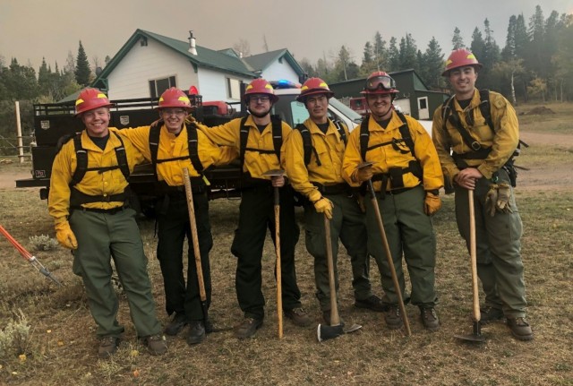 Cadet James Spear, (second from left), protecting a home while fighting the Mullen Fire