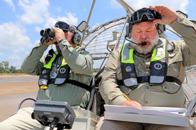 Tulsa District Biologist Stacy Dunkin (right) logs findings while Biologist Jason Person uses binoculars to search for Interior Least Tern nests on a sand bar in the Arkansas River July 7, 2020.  The U.S. Army Corps of Engineers, Tulsa District is...