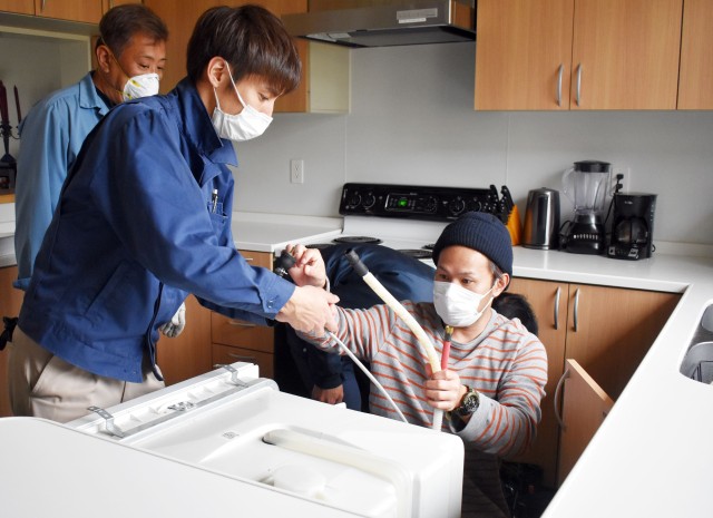 Members of the U.S. Army Garrison Japan maintenance team replace a dishwasher in a housing unit at Sagamihara Family Housing Area, Japan, April 21.