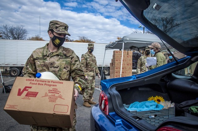 Staff Sgt. Samantha Sheehan, a human resources specialist with the Connecticut National Guard&#39;s 1st Battalion, 102nd Infantry Regiment, loads a box of groceries for a family at a drive-through food distribution point for the Farmers to Families Program in New Haven, Conn., Oct. 27, 2020. The ongoing mission is one of the many ways Guardsmen continue to serve their communities during the COVID-19 pandemic.