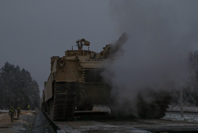 An M1 Abrams smokes to life before being off loaded from a rail car near the Pabrade Training Area, Lithuania, on Dec. 1, 2020. The tank belongs to 2nd Battalion, 8th Cavalry Regiment, 1st Armored Brigade Combat Team, 1st Cavalry Division....