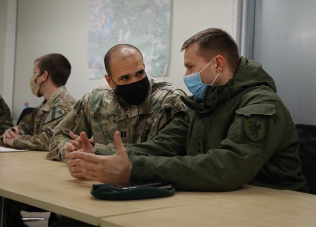 Capt. Dakota Slay, Stallion S6, talks to his Lithuanian counterpart Capt. Erlandas Kasperavicius, Griffin Brigade S6, during a Dec. 4, 2020, meet and greet at Pabrade Training Area, Lithuania. The joint forces met to discuss the best ways to...