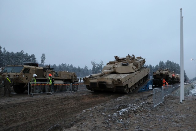 An M1 Abrams tank rolls down ramps from a rail car near Pabrade Training Area, Lithuania on Dec. 1, 2020. “This means we're here and ready to get to work,” said Sergeant Maj. Nathanael Green, the regiment's operations sergeant major. The...