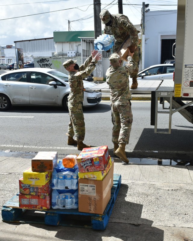 Fort Buchanan Religious Support Office (RSO) Command Chaplain, Maj. Keller, RSO NCO Sgt. 1st Class Spann, Garrison Commander Col. Corcoran and Garrison Command Sgt. Maj. Banks un-load over 600 pounds of food delivered to Bill’s Kitchen, donated...