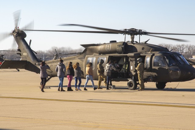 Spouses of Soldiers attached to 1st Combat Aviation Brigade board a UH-60 Black Hawk helicopter for their tour of Fort Riley from the sky on Dec. 5, 2020, in Fort Riley, Kansas. 1CAB hosted the event to foster an opportunity for the brigade to build a relationship with their Families. U.S. Army photo by Sgt. Joshua Oh, 19th Public Affairs Detachment