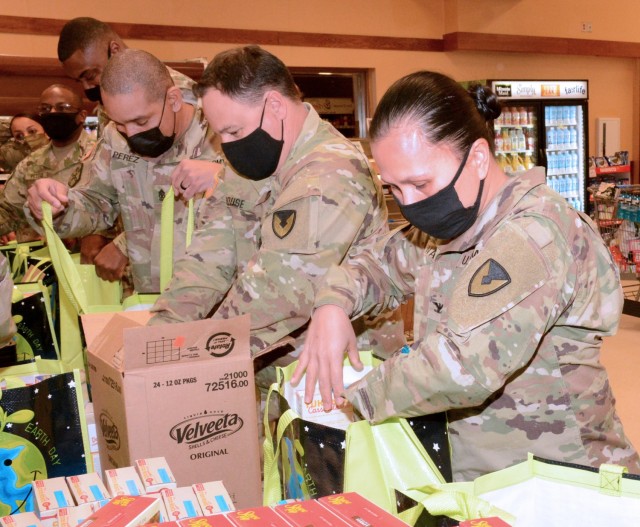 On Nov. 18 at the Fort Lee Commissary, Garrison Commander Col. Karin L. Watson, Command Sergeant Major James House, garrison CSM, Sgt. Maj. Hector Perez, Transportation Corps Reserve Affairs Proponency SGM, and other post leaders pack bags with Thanksgiving meal items. The commander and CSM worked with the commissary to come up with the food donations from industry partners. In all, 78 bags and a ham were distributed to military families at the end of last week.