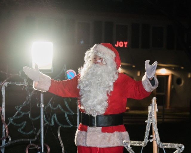 WIESBADEN, Germany -- Santa arrives at the live-streamed tree-lighting ceremony Dec. 4 on a firetruck just as the rain subsides on Clay Kaserne. As he proceeded to the platform, he said, "Ho! Ho! Ho! Merry Christmas" and waved.