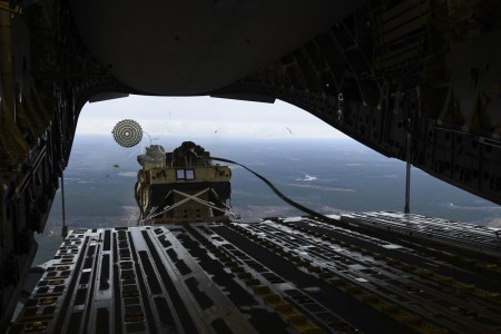 A loadmaster ejects a Humvee out of a C-17 Globemaster III over Pope Army Airfield, N.C., Feb. 19, 2020. 