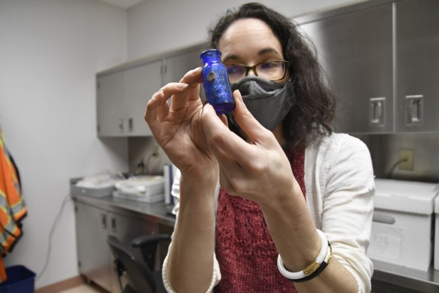 Tiffany Newman, a contract curator, shows off a bottle of Bromo-Seltzer at the Regional Archaeological Curation Facility where she works Oct. 6. The bottle was one artifact of many found at an installation construction site.  Bromo-Seltzer was a...