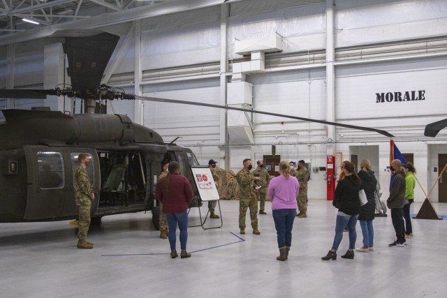 Spouses of Soldiers attached to 1st Combat Aviation Brigade learn about safety precautions when boarding an aircraft on Dec. 5, 2020, in Fort Riley, Kansas. Spouses were told to avoid the nose and tail of the aircraft at all times, as these areas are the most hazardous due to the rotors during operation. U.S. Army photo by Sgt. Joshua Oh, 19th Public Affairs Detachment