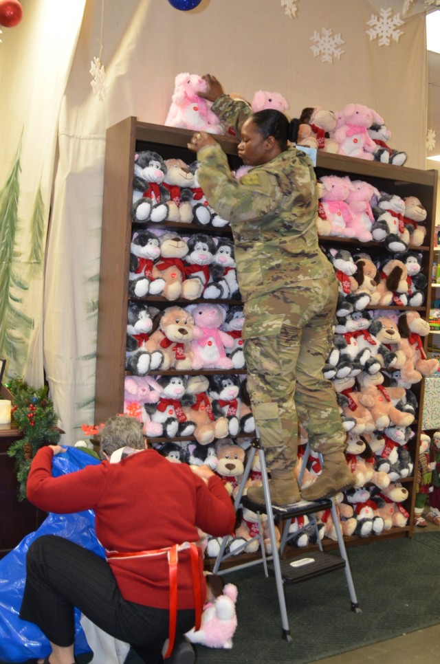 FORT Lee, VA. - Volunteers from last year's Holiday Helper stock the shelves of the "store" to prepare for the annual holiday event.
