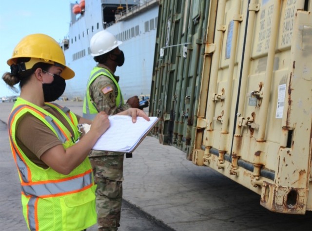 Petty Officer Ilene Cerda and Staff Sgt. Deontre Austin take the numbers off of containers as they are offloaded from the USNS Fisher at Pearl Harbor on Dec. 3.