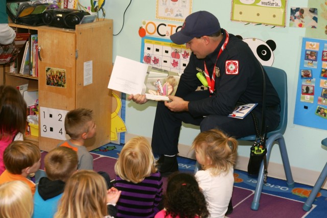 Firefighter Matt Steele reads a book to children at the Fort McCoy Child Development Center Oct. 6, 2014, as part of activities for National Fire Prevention Week. In observance of both National Fire Prevention Month and National Fire Prevention...