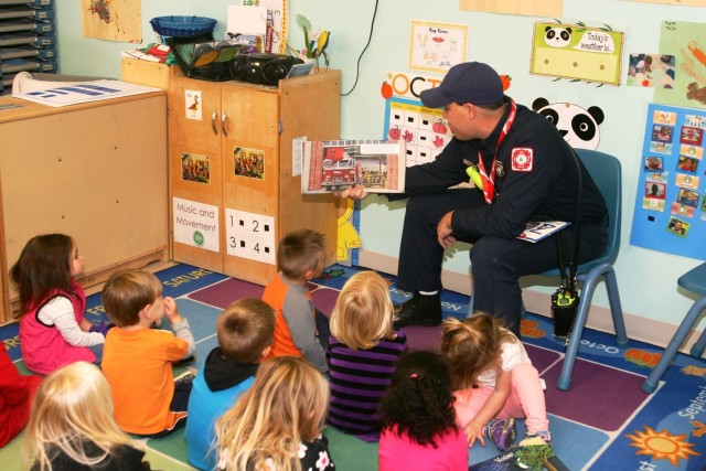 Firefighter Matt Steele reads a book to children at the Fort McCoy Child Development Center Oct. 6, 2014, as part of activities for National Fire Prevention Week. In observance of both National Fire Prevention Month and National Fire Prevention...