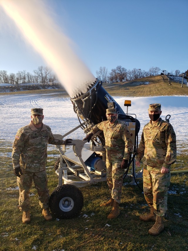 Command Sgt. Maj. Paul Mantha, garrison command sergeant major; Garrison Commander Col. Michael Poss; and Deputy Garrison Commander Lt. Col Alexander Carter pose with the  the snow-making machine Dec. 3, 2020, at Whitetail Ridge Ski Area at Fort McCoy, Wis. Staff members began making snow Dec. 3 for the 2020-21 winter season. (Photo contributed by Scott Abell/Directorate of Family and Morale, Welfare, and Recreation.)