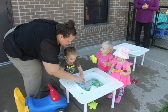 Angela Kast, assistant director of the Child Development Center, helps toddlers with a water activity Aug. 8, 2017, at Fort McCoy, Wis. The Fort McCoy CDC was recently reaccredited through the National Association for the Education of Young...