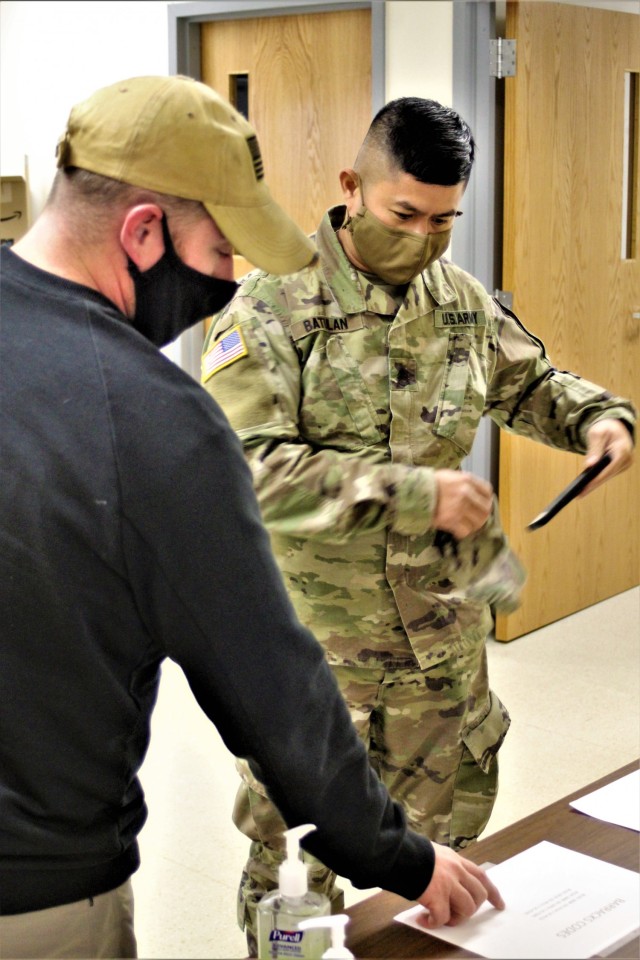 A Soldier signs up to be a student for the Cold-Weather Operations Course (CWOC) with help from instructor Joe Ernst on Dec. 3, 2020, at Fort McCoy, Wis. CWOC students are trained on a variety of cold-weather subjects, including snowshoe training...