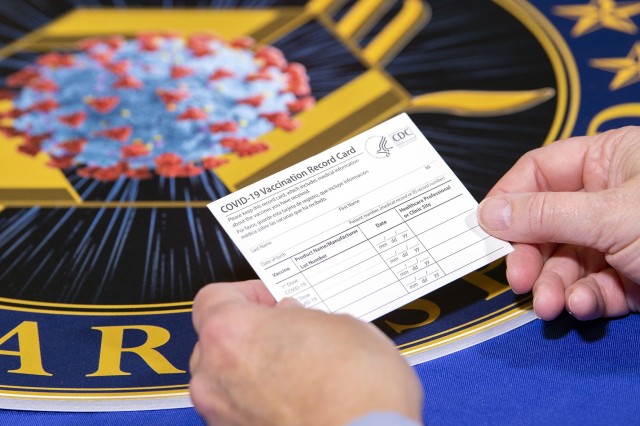 A Department of Health and Human Services employee holds a COVID-19 vaccine record card Nov. 13, 2020, in Washington D.C. The cards will be sent out as part of vaccination kits from Operation Warp Speed, which is an effort by several U.S....