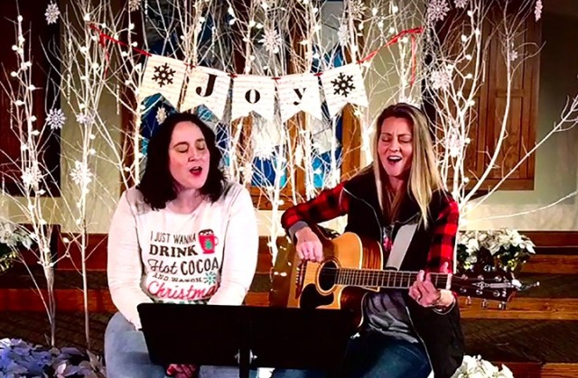 Caitlyn Mair, praise and worship leader for Protestant Women of the Chapel, and singer Kayla Atkins perform "Oh Holy Night" at the conclusion of the PWOC Christmas program Dec. 8 at Frontier Chapel. The event was attended in person only by those...