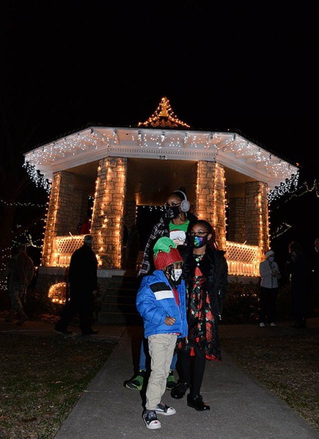 Jennifer Wildy, spouse of deployed soldier Sgt. 1st Class Damion Wildy, and their children 7-year-old Dahlia and 5-year-old Steffen look around at Zais Park after helping throw the switch to light the park's gazebo and trees during the annual...