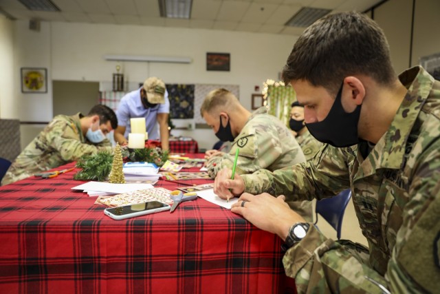 Soldiers with 1st Battalion, 27th Infantry Regiment "Wolfhounds", 2nd Infantry Brigade Combat Team, 25th Infantry Division, write holiday cards to send to children at the Holy Family Home orphanage on December 4, 2020 at Schofield Barracks, Hawaii. 1-27 IN and the Holy Family Home orphanage in Osaka, Japan, have an enduring relationship dating back to just after World War II, when Soldiers took up a collection for the orphanage during the holiday season in 1949. (U.S. Army photo by Staff Sgt. Thomas Calvert)