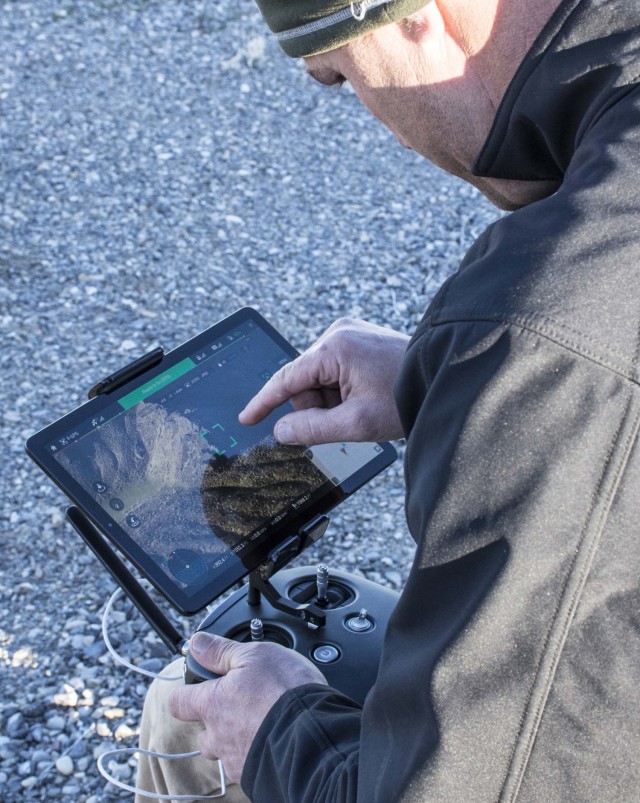 A project team member controls a small unmanned aircraft system (sUAS) to get close to a golden eagle nest to determine if the nest was active. Dugway Proving Ground photo.