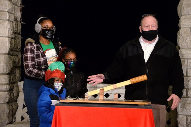 Jennifer Wildy, spouse of deployed soldier Sgt. 1st Class Damion Wildy, and their children 7-year-old Dahlia and 5-year-old Steffen listen to Glenn Hewitt, Family and Morale, Welfare and Recreation director, explain how the annual lighting...