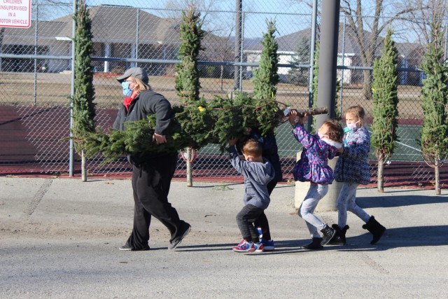 Military family members carry a tree Dec. 4, 2020, during the Trees for Troops event at the South Post Housing area at Fort McCoy, Wis. Eighty free Christmas trees were distributed to Fort McCoy military families thanks to the Trees for Troops organization. This was fifth consecutive year the trees were distributed. The Directorate of Public Works Housing Division coordinated the distribution. (U.S. Army Photo by Scott T. Sturkol, Public Affairs Office, Fort McCoy, Wis.)