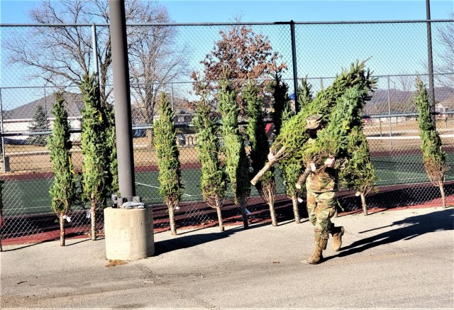 A Soldier carries a tree Dec. 4, 2020, during the Trees for Troops event at the South Post Housing area at Fort McCoy, Wis. Eighty free Christmas trees were distributed to Fort McCoy military families thanks to the Trees for Troops organization. This was fifth consecutive year the trees were distributed. The Directorate of Public Works Housing Division coordinated the distribution. (U.S. Army Photo by Scott T. Sturkol, Public Affairs Office, Fort McCoy, Wis.)