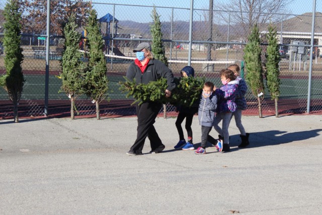 Military family members carry a tree Dec. 4, 2020, during the Trees for Troops event at the South Post Housing area at Fort McCoy, Wis. Eighty free Christmas trees were distributed to Fort McCoy military families thanks to the Trees for Troops organization. This was fifth consecutive year the trees were distributed. The Directorate of Public Works Housing Division coordinated the distribution. (U.S. Army Photo by Scott T. Sturkol, Public Affairs Office, Fort McCoy, Wis.)