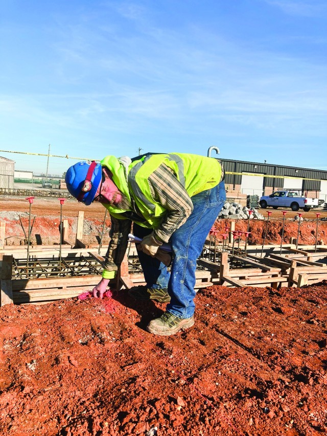 Jeff Abbott of Haase Mechanical Contractors helps lay markers Dec. 9, at the construction site of the Army Field Support Battalion Installation Maintenance Division complex on post.