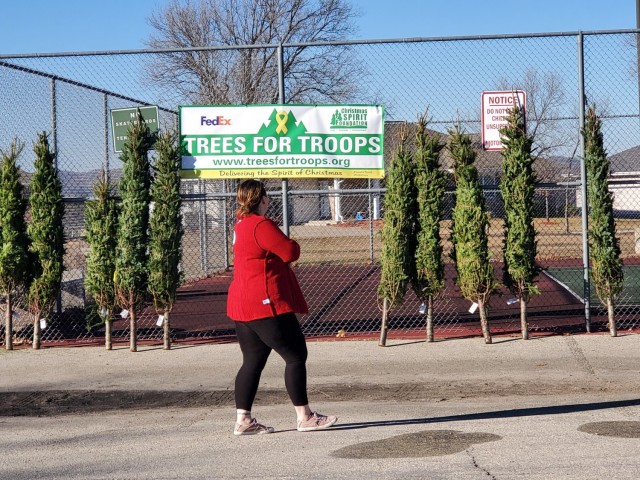 Military family members carry a tree Dec. 4, 2020, during the Trees for Troops event at the South Post Housing area at Fort McCoy, Wis. Eighty free Christmas trees were distributed to Fort McCoy military families thanks to the Trees for Troops...