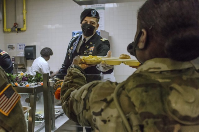 An officer with 1st Battalion, 61st Infantry Regiment, serves a meal to a trainee during Thanksgiving dinner. For many trainees this is the first time they spent
the holiday away from their Families. (photo by Ms. Tori Evans)