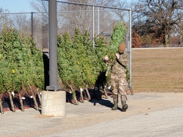 Military family members carry a tree Dec. 4, 2020, during the Trees for Troops event at the South Post Housing area at Fort McCoy, Wis. Eighty free Christmas trees were distributed to Fort McCoy military families thanks to the Trees for Troops organization. This was fifth consecutive year the trees were distributed. The Directorate of Public Works Housing Division coordinated the distribution. (U.S. Army Photo by Scott T. Sturkol, Public Affairs Office, Fort McCoy, Wis.)